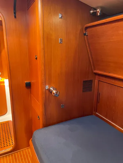 Disco Lemonade Yacht Photos Pics Interior cabin of a 1992 Nautor Swan 68 yacht with wooden paneling and blue cushion.