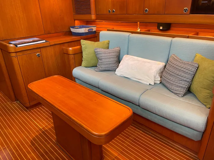 Disco Lemonade Yacht Photos Pics Interior of 1992 Nautor Swan 68 yacht with wooden table and cushioned seating.