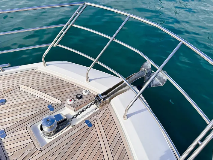 Tamara II Yacht Photos Pics Azimut 66 FLY 2018 yacht bow with anchor and teak deck, on calm blue water.