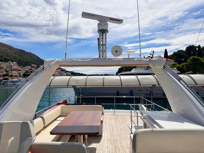 Tamara II Yacht Photos Pics Azimut 66 FLY 2018 yacht deck with seating and table, docked in scenic marina.