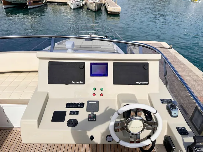 Tamara II Yacht Photos Pics Flybridge helm of 2018 Azimut 66 FLY yacht with navigation controls, docked at marina.