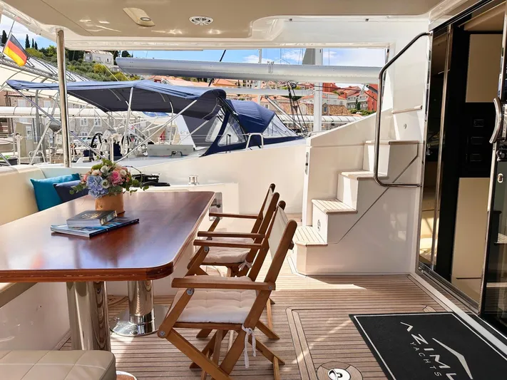 Tamara II Yacht Photos Pics Luxurious 2018 Azimut 66 FLY yacht deck with dining area and elegant wooden chairs.