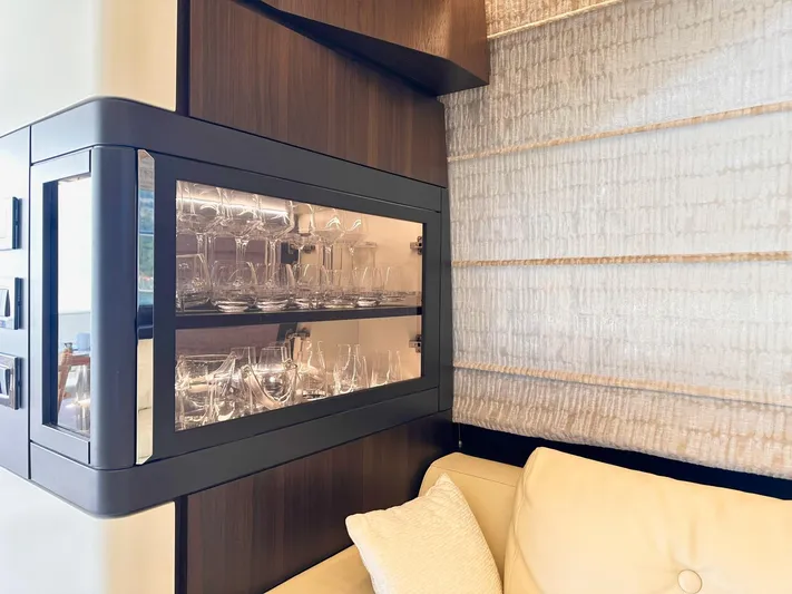 Tamara II Yacht Photos Pics Luxurious interior of 2018 Azimut 66 FLY yacht with glassware display and elegant seating.