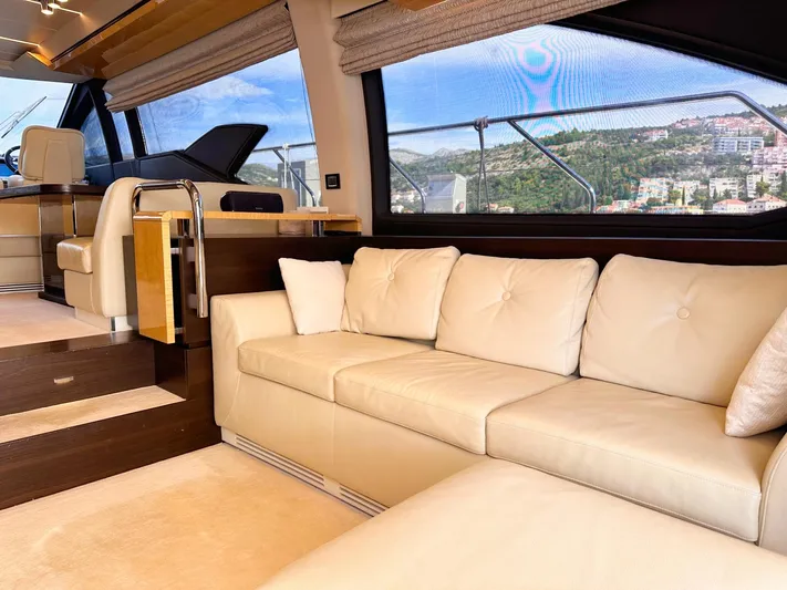 Tamara II Yacht Photos Pics Luxurious interior of 2018 Azimut 66 FLY yacht with cream leather sofa and scenic window view.