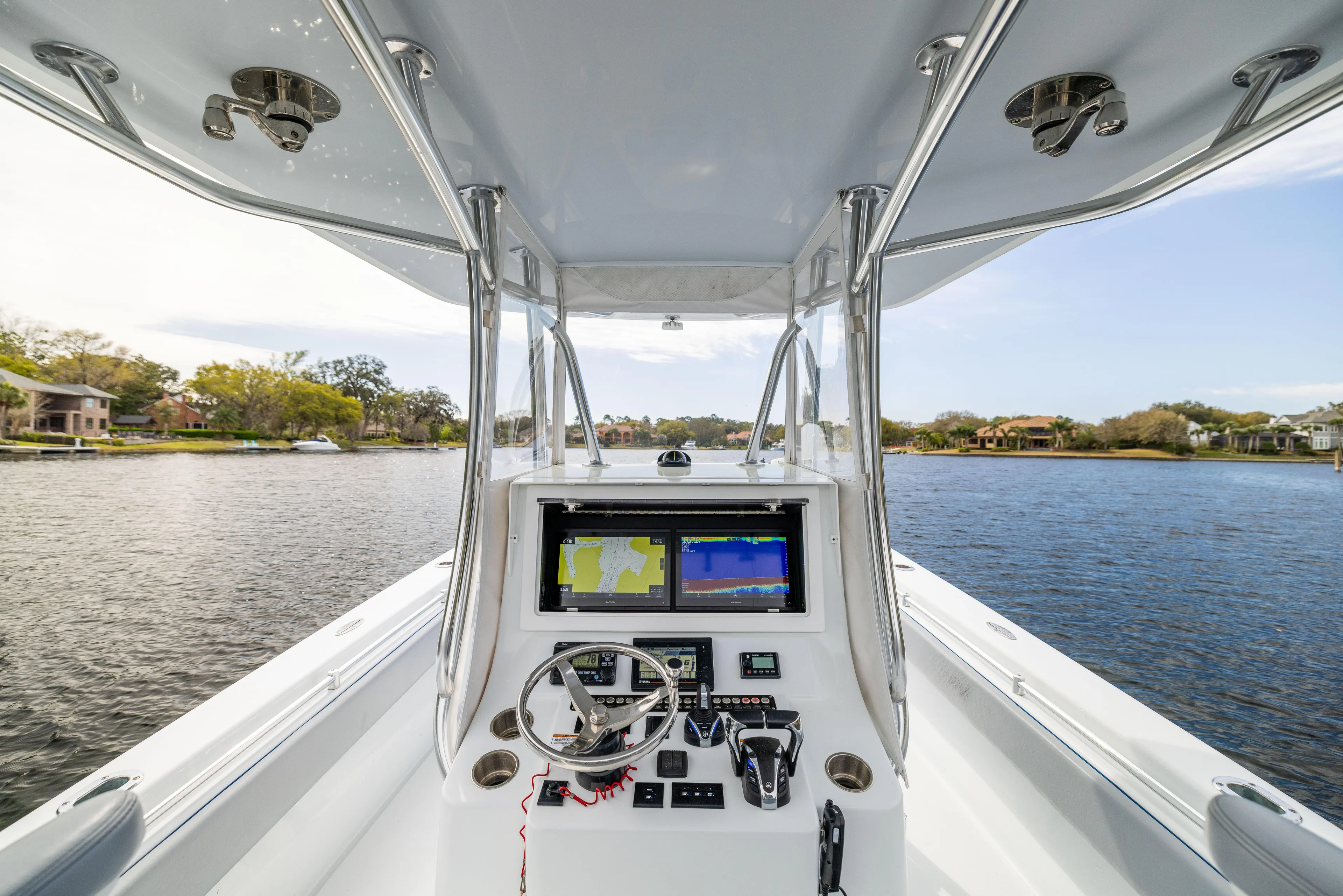  Yacht Photos Pics 2022 Contender 35ST boat helm with navigation screens on a calm waterway.