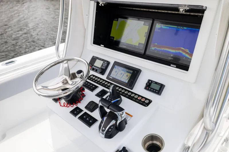  Yacht Photos Pics Control panel of 2022 Contender 35ST boat with navigation screens and steering wheel.