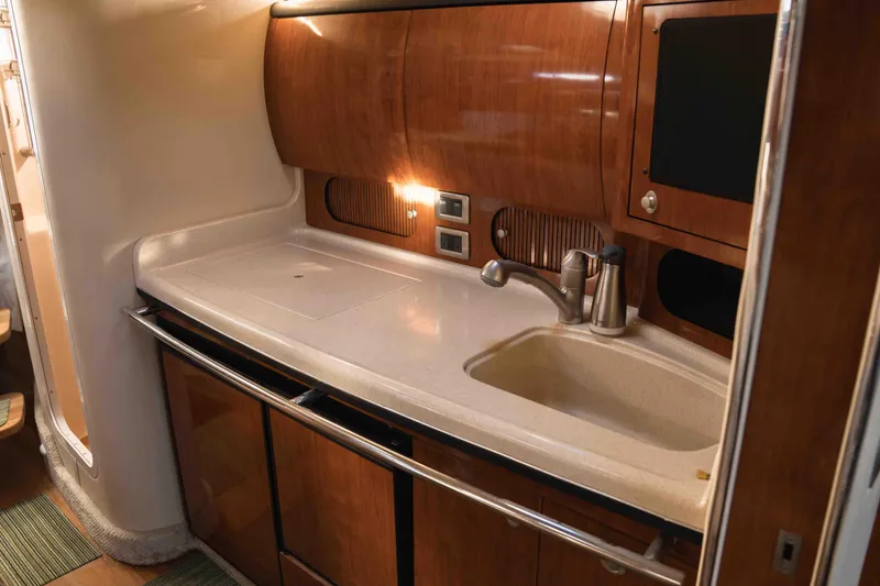  Yacht Photos Pics 2004 Sea Ray 360 Sundancer yacht kitchen with wooden cabinetry and modern sink.