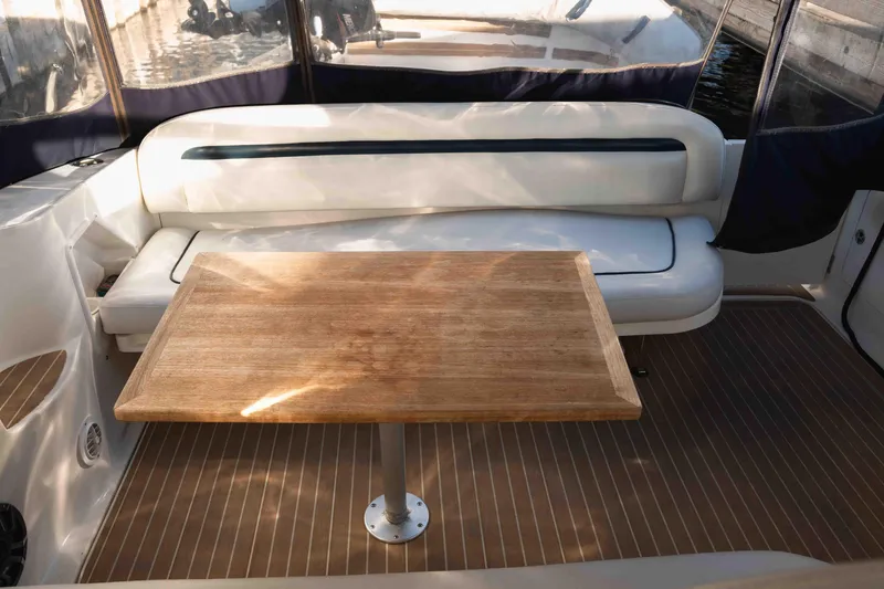  Yacht Photos Pics 2004 Sea Ray 360 Sundancer interior with wooden table and cushioned seating.