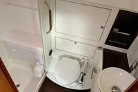 Compact bathroom in a 2012 Allures 45 yacht, featuring a toilet, sink, and shower area.