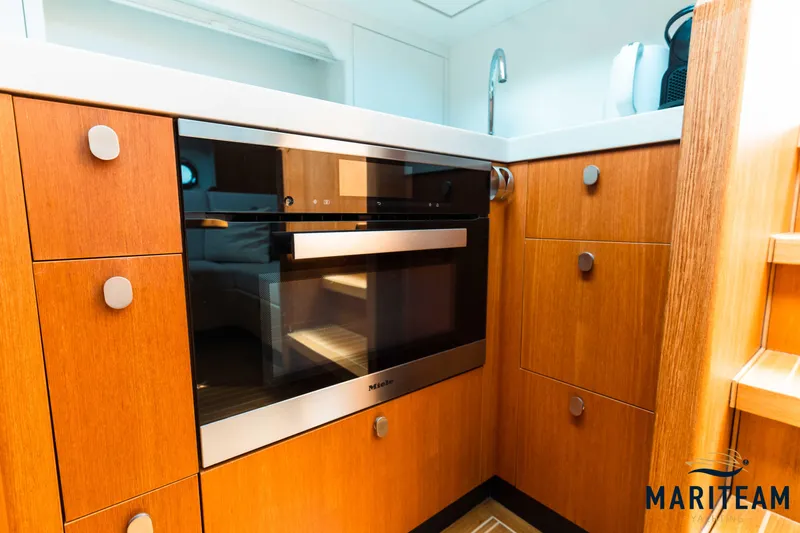 Onderonsie Yacht Photos Pics Modern kitchen area in 2017 Breedendam MTB fourzero Wheelhouse yacht with wood cabinetry and built-in oven.
