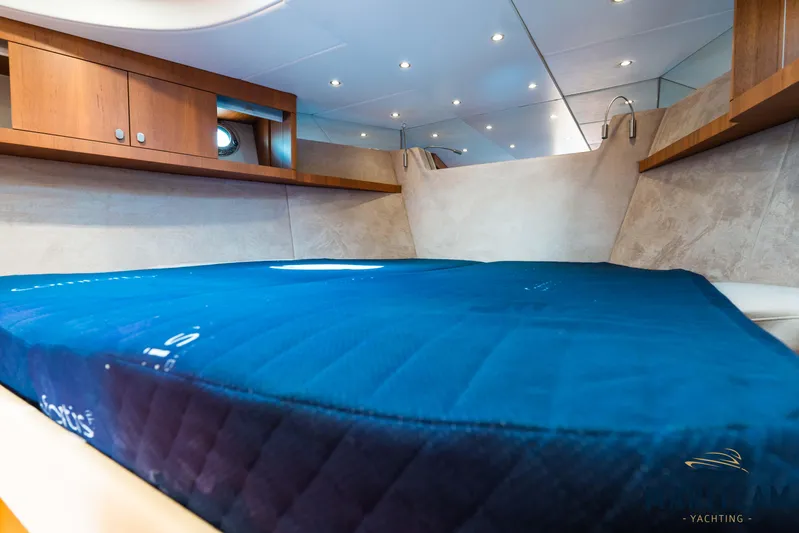 Onderonsie Yacht Photos Pics Cozy interior of 2017 Breedendam MTB fourzero Wheelhouse with blue bedding and wooden cabinets.