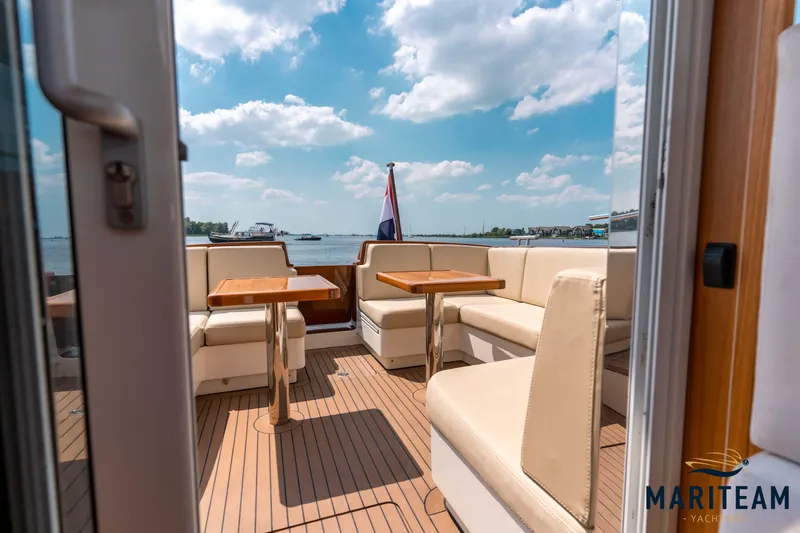 Onderonsie Yacht Photos Pics 2017 Breedendam MTB fourzero Wheelhouse yacht interior with seating and tables, open to scenic view.