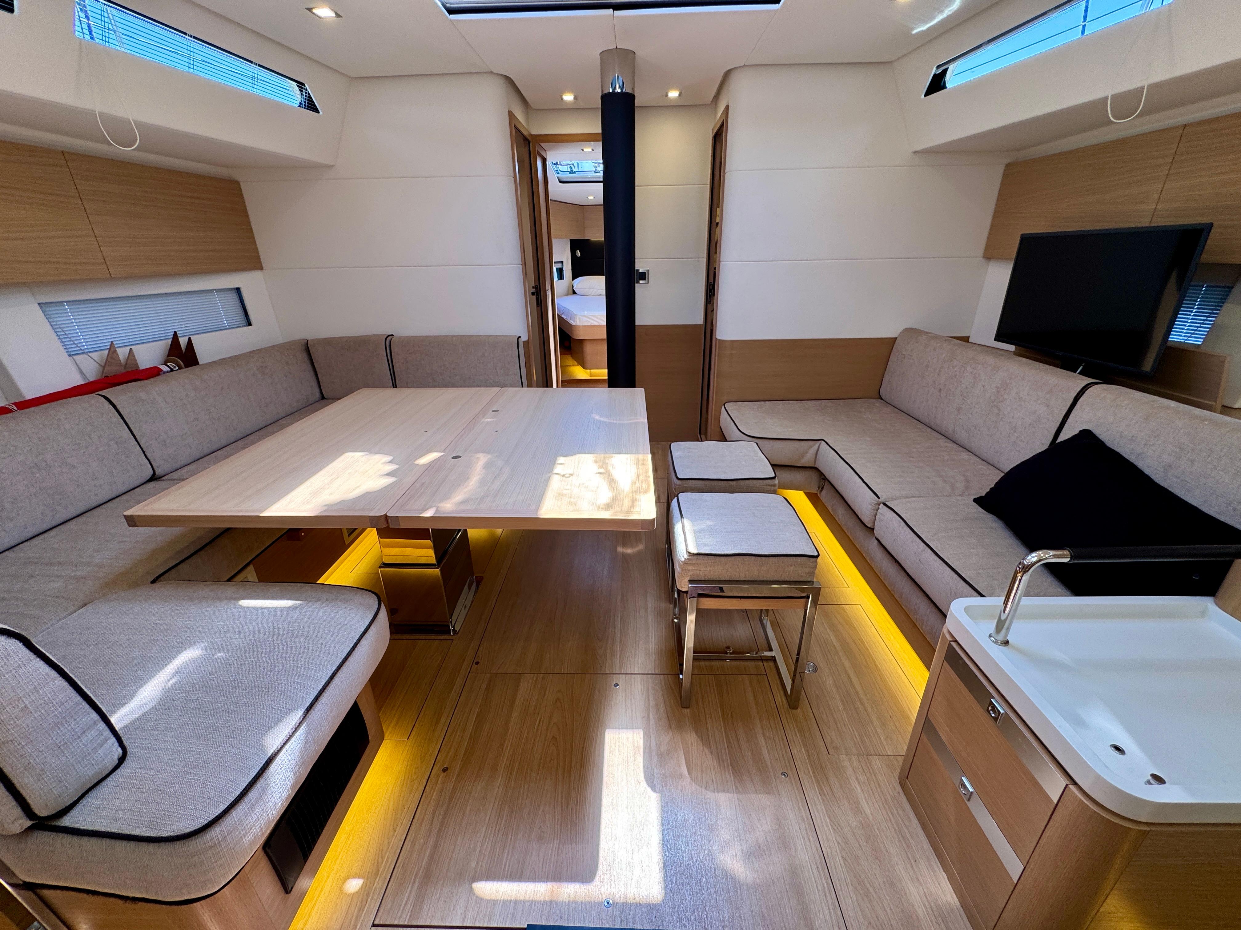 Luxurious interior of a 2017 Amel 50 yacht with modern seating and wooden finishes.