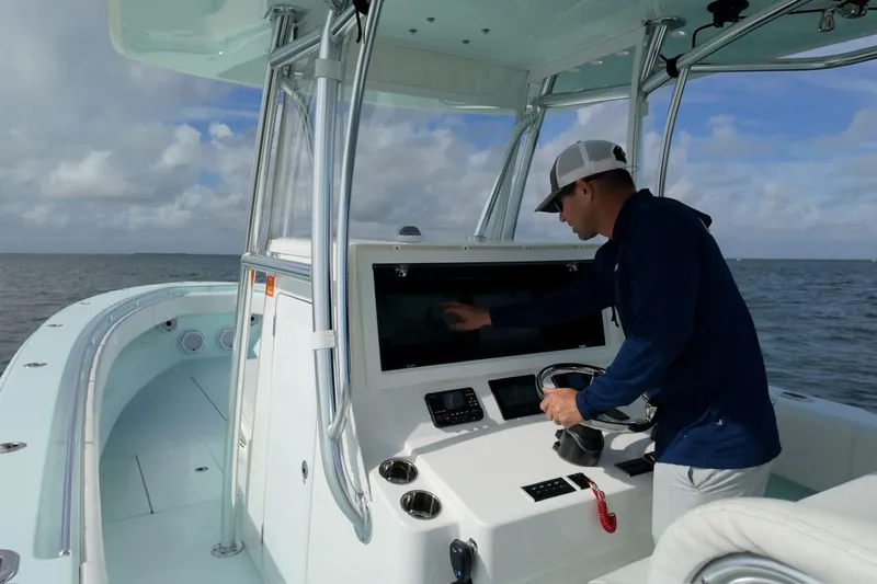 Yacht Photos Pics 2025 Contender 39 ST boat with person navigating touchscreen at sea.