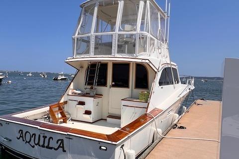1985 Post 43 Convertible yacht "Aquila" docked at marina.