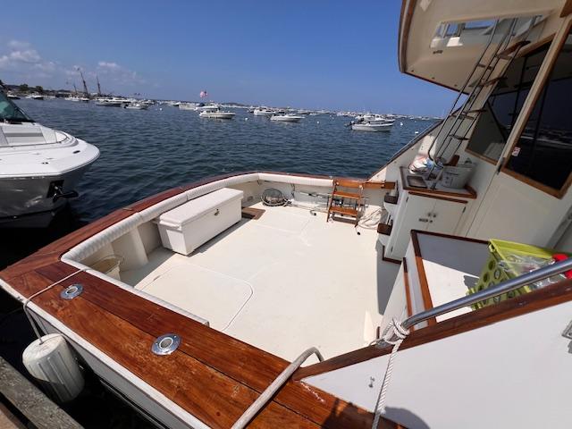 1985 Post 43 Convertible yacht with spacious deck, docked in a busy marina.
