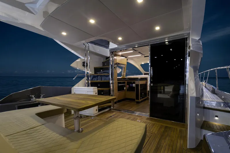  Yacht Photos Pics Luxurious 2025 Cobrey 52 FLY yacht interior with elegant seating and modern kitchen at night.