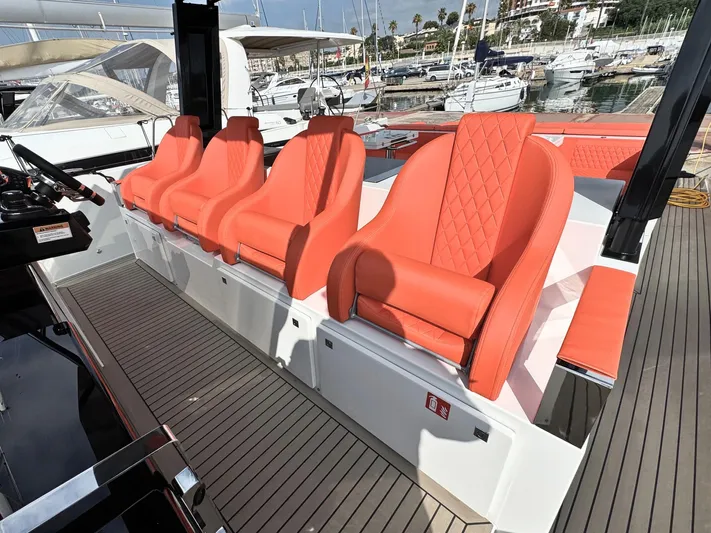  Yacht Photos Pics 2025 De Antonio Yachts D50 with luxurious orange seating in a marina setting.
