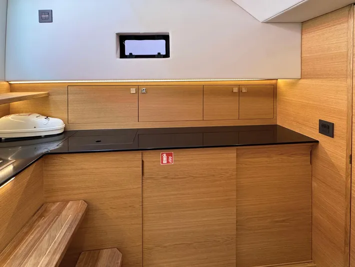  Yacht Photos Pics Modern wooden interior of 2025 De Antonio Yachts D50, featuring sleek cabinetry and compact design.
