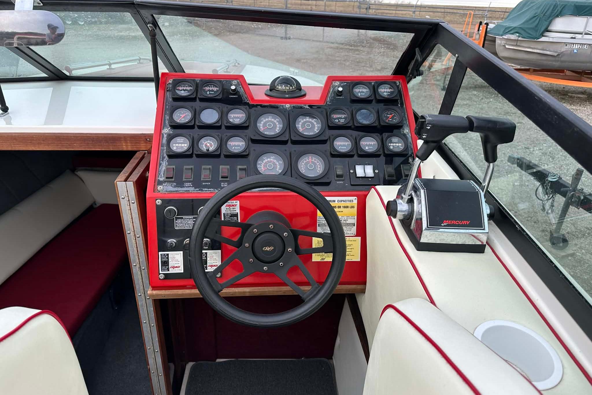1987 IMP 255 Eleganza boat dashboard with steering wheel and Mercury throttle controls.
