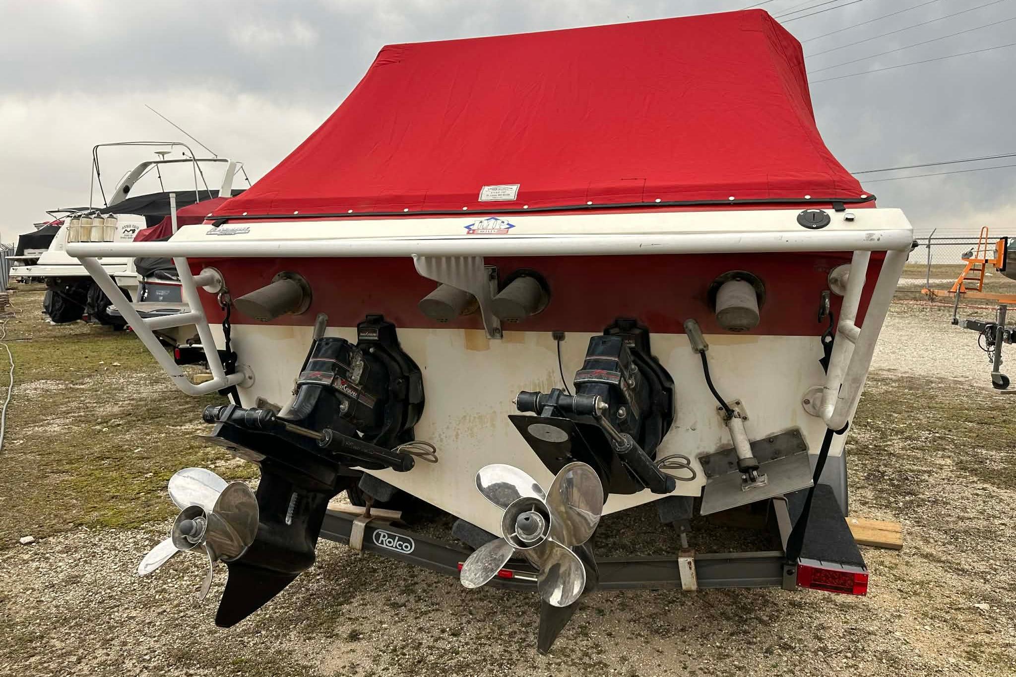1987 IMP 255 Eleganza boat with red cover and dual propellers.