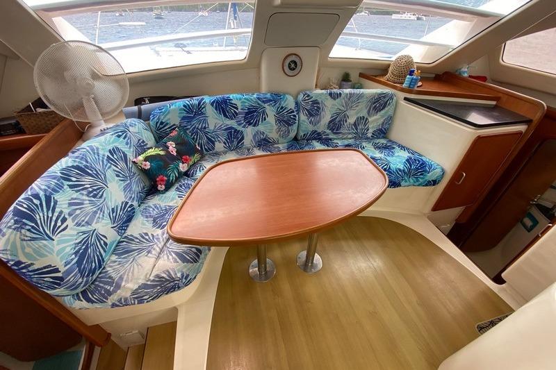 Interior of 2006 Leopard 40 catamaran with tropical-themed seating and wooden table.
