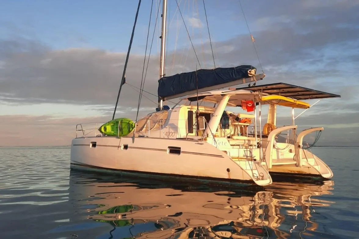 2006 Leopard 40 catamaran on calm water at sunset, featuring a kayak and solar panels.