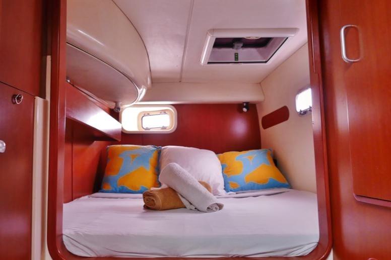 Cozy cabin interior of 2006 Leopard 40 catamaran with colorful pillows and towels.