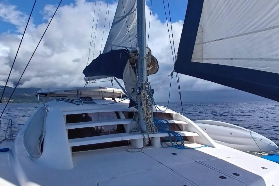 2006 Leopard 40 catamaran sailing on open sea under cloudy skies.