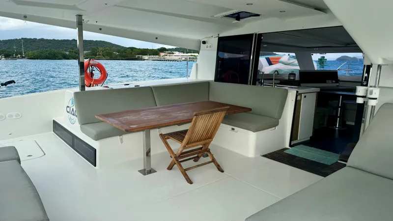  Yacht Photos Pics 2019 Fountaine Pajot Lucia 40 yacht interior with seating and table, overlooking serene waters.