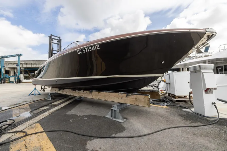  Yacht Photos Pics 2013 Riva Aquariva Super boat on dry dock, sleek black hull, overcast sky.