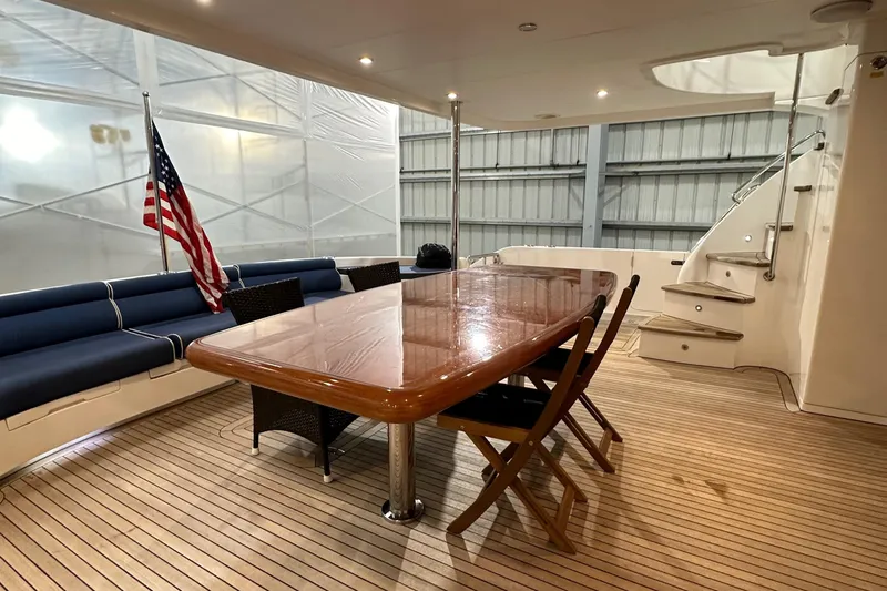  Yacht Photos Pics Luxurious Horizon PC60 yacht deck with wooden table, chairs, and American flag, 2017 model.