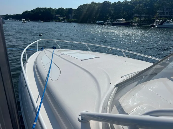 Yacht Photos Pics 2019 Intrepid 407 Cuddy boat on a sunny day, docked in a scenic harbor.