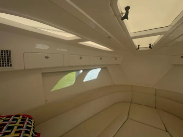  Yacht Photos Pics Interior cabin of 2019 Intrepid 407 Cuddy with beige seating and overhead storage.