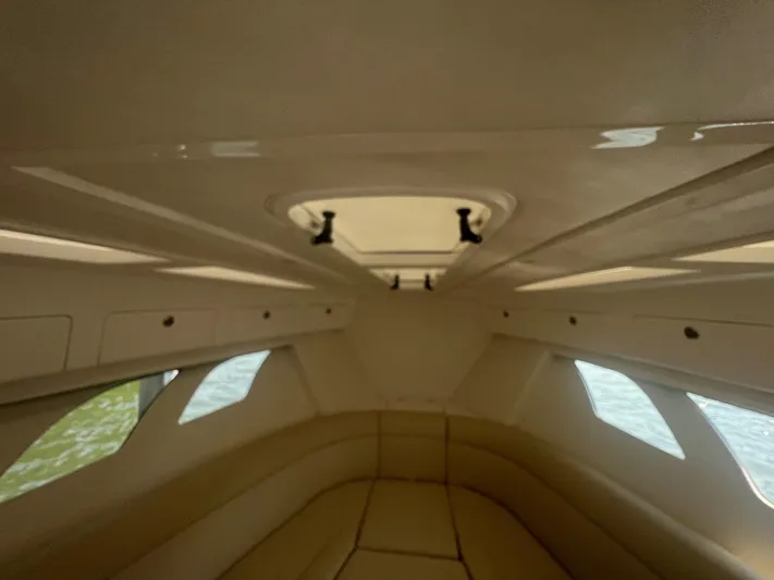  Yacht Photos Pics Interior cabin of 2019 Intrepid 407 Cuddy boat with beige seating and windows.