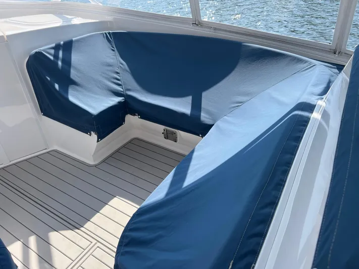 Yacht Photos Pics 2019 Intrepid 407 Cuddy boat interior with blue seating and teak flooring.