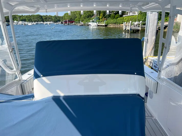  Yacht Photos Pics 2019 Intrepid 407 Cuddy boat with blue covers docked by a scenic waterfront.