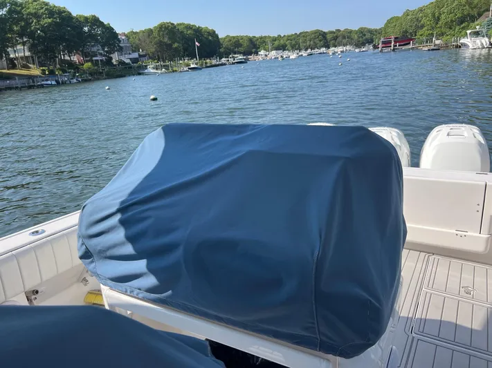  Yacht Photos Pics 2019 Intrepid 407 Cuddy boat with covered seating, docked in a scenic marina.