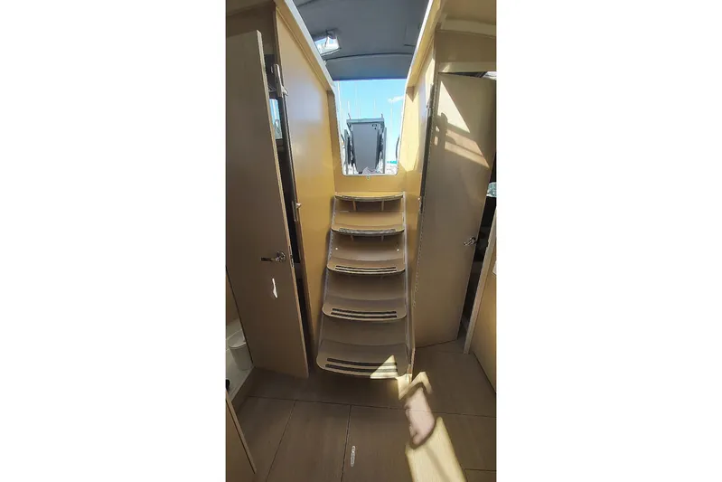 Nafsika Yacht Photos Pics Interior view of 2020 Beneteau Oceanis 41.1 yacht, featuring wooden stairs and cabin doors.