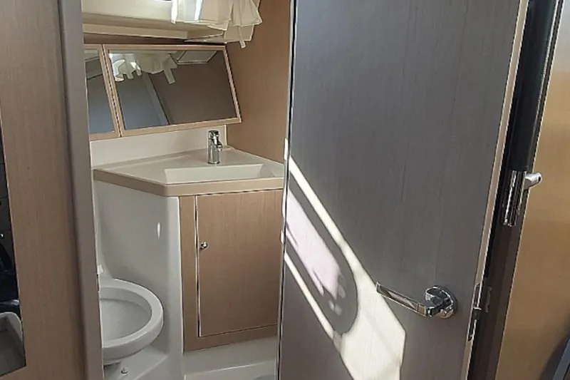 Nafsika Yacht Photos Pics 2020 Beneteau Oceanis 41.1 yacht bathroom with sink, mirror, and toilet.