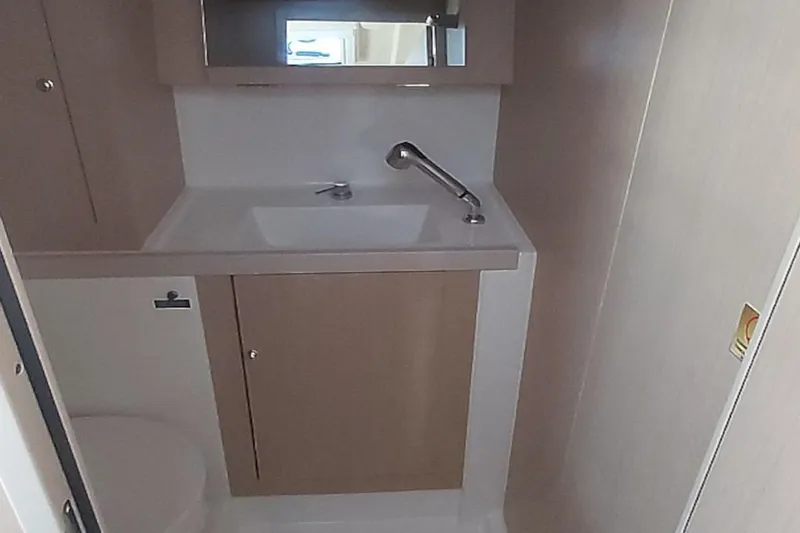 Nafsika Yacht Photos Pics Beneteau Oceanis 41.1 2020 yacht bathroom with sink, mirror, and storage cabinet.