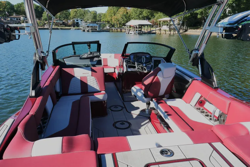  Yacht Photos Pics 2022 MasterCraft X22 boat interior with red and white seating, on a scenic lake.