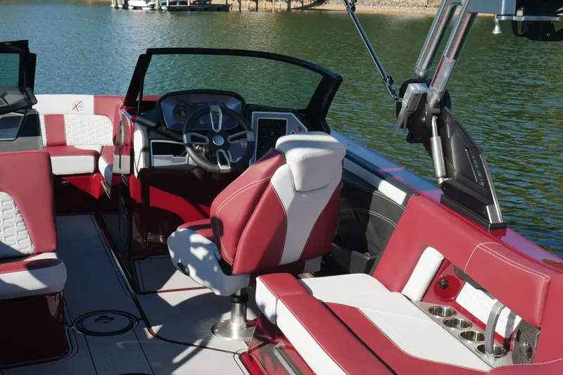 Yacht Photos Pics 2022 MasterCraft X22 boat interior with red and white seating, steering wheel, and dashboard.