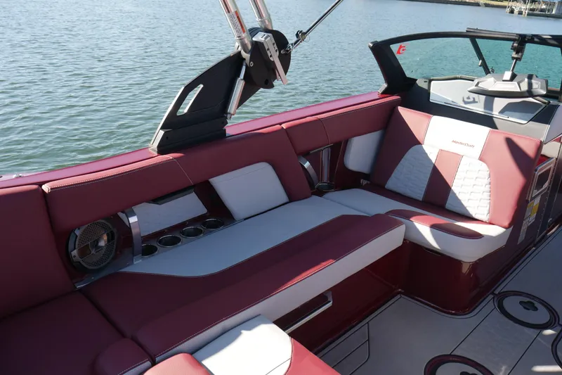  Yacht Photos Pics 2022 MasterCraft X22 boat interior with red and white seating, cup holders, and speaker.