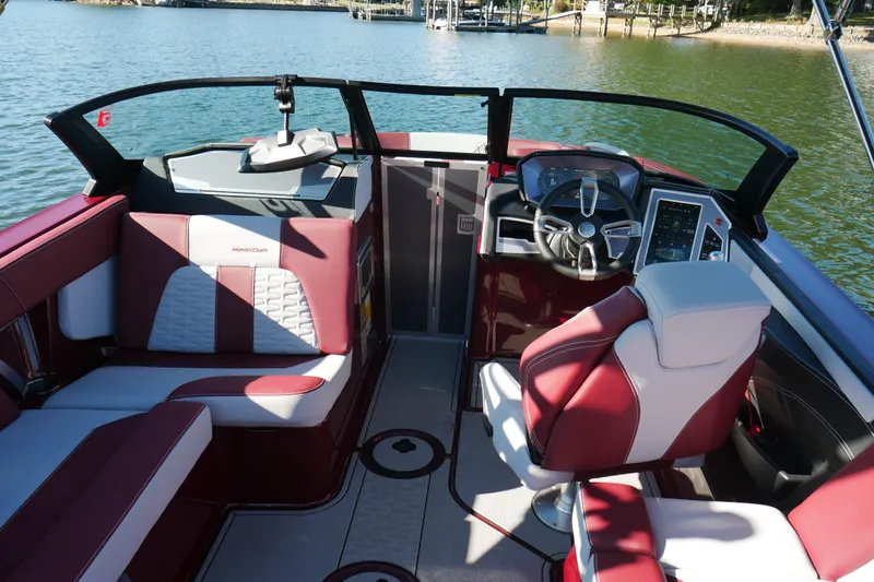  Yacht Photos Pics 2022 MasterCraft X22 boat interior with red and white seating, steering wheel, and control panel.