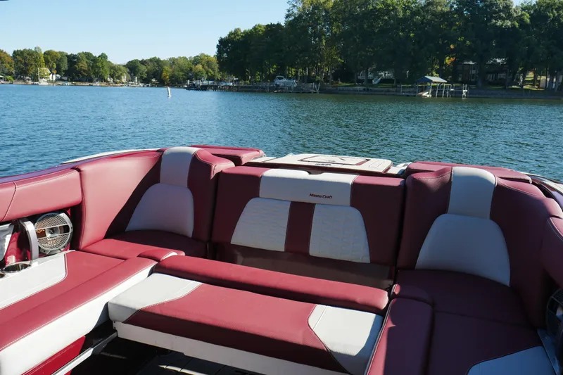  Yacht Photos Pics 2022 MasterCraft X22 boat interior with red and white seating on a lake.