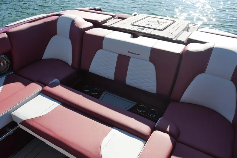  Yacht Photos Pics 2022 MasterCraft X22 boat interior with maroon and white seating on water.