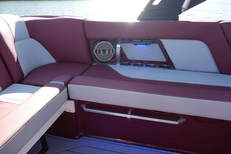  Yacht Photos Pics 2022 MasterCraft X22 boat interior with maroon and white seating, cup holders, and speaker.