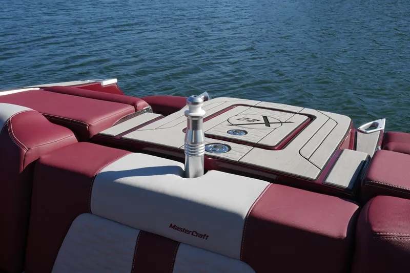  Yacht Photos Pics 2022 MasterCraft X22 boat with maroon and white seating on a calm lake.
