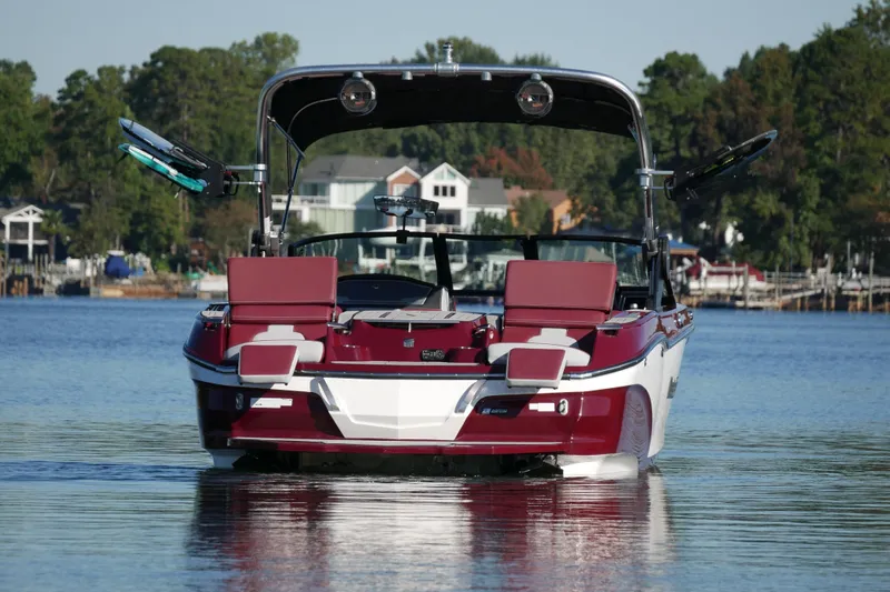  Yacht Photos Pics 2022 MasterCraft X22 boat on a serene lake with a scenic backdrop.